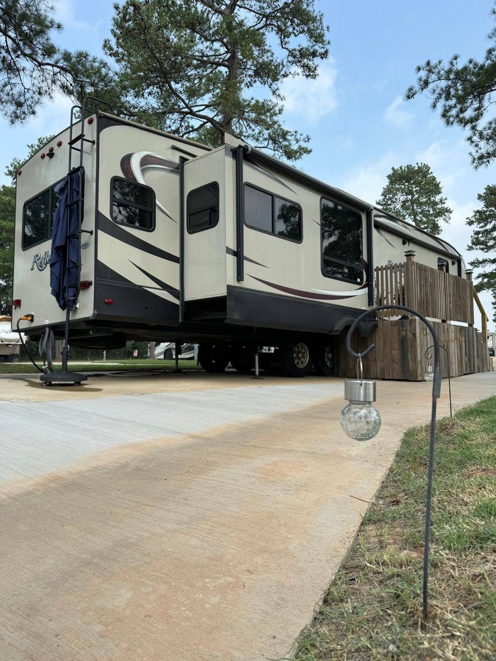 Occupied concrete pull-through RV site at Hidden Lake RV Resort